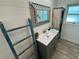 Bright bathroom features rustic vanity with a decorative mirror and vintage-style storage cabinet at 12300 4Th E St, Treasure Island, FL 33706