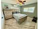 Comfortable bedroom featuring a ceiling fan, AC unit, and weathered-look floors at 12300 4Th E St, Treasure Island, FL 33706