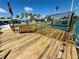 Wooden boat dock has bench seating and a boat lift with canal views at 12300 4Th E St, Treasure Island, FL 33706