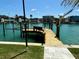A private wooden dock extends into the clear water, providing access and a serene spot to enjoy the waterfront at 12300 4Th E St, Treasure Island, FL 33706