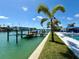 Exterior view of property with dock and waterfront, enhanced with lush landscaping at 12300 4Th E St, Treasure Island, FL 33706