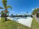 Full exterior view of the home showcasing its waterfront location, pool, and patio at 12300 4Th E St, Treasure Island, FL 33706