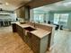 Olive green kitchen with a stainless steel sink and views of the living area and a waterfront patio at 12300 4Th E St, Treasure Island, FL 33706