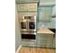 Kitchen featuring stainless steel oven/microwave combo, grey cabinets, backsplash and light countertops at 12300 4Th E St, Treasure Island, FL 33706