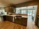 Olive green kitchen with a stainless steel sink and views of the living area and a waterfront patio at 12300 4Th E St, Treasure Island, FL 33706