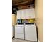 White washer and dryer with shelf and cabinet storage at 12300 4Th E St, Treasure Island, FL 33706