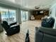 Open living room featuring wood tile floors, ceiling fan, and views of outdoor patio and waterfront at 12300 4Th E St, Treasure Island, FL 33706