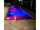 A pristine in-ground pool, lit up with vibrant colors, alongside a luxurious hot tub for ultimate relaxation at 12300 4Th E St, Treasure Island, FL 33706
