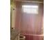 Bathroom with decorative wallpaper, pink shower curtain, toilet, and sink at 12801 Winding Way, Hudson, FL 34667