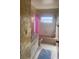 Bathroom showcasing patterned wallpaper, pink shower curtain, and a tiled floor at 12801 Winding Way, Hudson, FL 34667