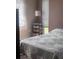Bedroom features a bed with a light blue comforter and lamp on a table with drawers at 12801 Winding Way, Hudson, FL 34667