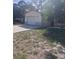 A single-story home with a white garage door, complemented by a tree at 12801 Winding Way, Hudson, FL 34667