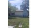 View of the side of the home with tidy yard and neutral exterior paint at 12801 Winding Way, Hudson, FL 34667