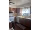 Kitchen with white appliances, wooden cabinets, and a window at 12801 Winding Way, Hudson, FL 34667