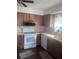 Kitchen with white appliances, wood cabinets, and dark wood floors at 12801 Winding Way, Hudson, FL 34667