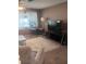 Inviting living room featuring large rug, tv, and comfortable seating area at 12801 Winding Way, Hudson, FL 34667