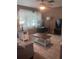 Cozy living room features a ceiling fan, window, lamp, coffee table and television set in a neutral color scheme at 12801 Winding Way, Hudson, FL 34667
