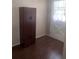 A room with laminate flooring, with a dark wooden storage cabinet next to the door at 12801 Winding Way, Hudson, FL 34667