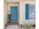 Close up view of the blue front door, sidelight window, and decorative landscaping, offering a welcoming entrance at 12910 Leadwood Dr, Riverview, FL 33579