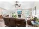 Bright living room featuring a ceiling fan, fireplace, leather furniture, and sliding glass doors to the backyard at 12910 Leadwood Dr, Riverview, FL 33579