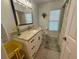 Bathroom with granite counters, patterned floors, and natural light from a window at 13133 Roseanna Dr, Spring Hill, FL 34609