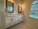 Bathroom featuring dual sinks with white cabinetry, granite countertop, and modern fixtures at 13133 Roseanna Dr, Spring Hill, FL 34609