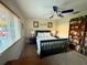 Comfortable bedroom with a blue ceiling fan, wooden bed frame, and plenty of natural light at 13133 Roseanna Dr, Spring Hill, FL 34609