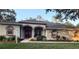 Single-story home featuring a red front door, decorative columns, and a well-kept lawn at 13133 Roseanna Dr, Spring Hill, FL 34609