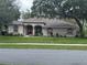Charming single-story home with mature trees, a well-maintained lawn, and a welcoming double-door entrance at 13133 Roseanna Dr, Spring Hill, FL 34609