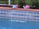 Close up of pool waterfall detail and tiled pool surround with decorative snail statues at 13133 Roseanna Dr, Spring Hill, FL 34609