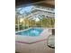 Screened-in pool area with a spacious patio and lush landscaping, perfect for relaxation at 13133 Roseanna Dr, Spring Hill, FL 34609