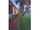 View of home's side yard, featuring lush lawn, landscaping, and mature shade trees at 13133 Roseanna Dr, Spring Hill, FL 34609