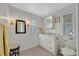 Bright bathroom with a modern vanity, decorative mirror and white fixtures at 134 W Saint Annes Cir, Apollo Beach, FL 33572