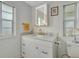 Bright bathroom with white marble countertops, modern fixtures, and a stylish, lighted mirror at 134 W Saint Annes Cir, Apollo Beach, FL 33572