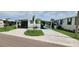 Charming single-story home featuring a well-maintained lawn, palm trees, and a paved driveway at 134 W Saint Annes Cir, Apollo Beach, FL 33572