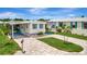 Charming home boasts a lovely, paved driveway, carport, and welcoming curb appeal under a bright sky at 134 W Saint Annes Cir, Apollo Beach, FL 33572