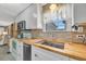 Well-lit kitchen with stainless steel appliances, wood countertops, and backsplash at 134 W Saint Annes Cir, Apollo Beach, FL 33572
