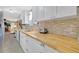 Bright kitchen featuring butcher block counters, modern appliances and a stylish backsplash at 134 W Saint Annes Cir, Apollo Beach, FL 33572
