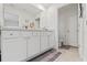 Bright bathroom featuring white vanity, double sinks, and tile flooring with a convenient toilet room at 13765 Whiskey Daisy Dr, Dade City, FL 33525