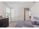 Neutral bedroom with closet and adjoining doorway, complemented by a dresser and comfortable queen-sized bed at 13765 Whiskey Daisy Dr, Dade City, FL 33525