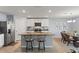 Stylish kitchen featuring an island with bar seating, stainless appliances, and open dining area at 13765 Whiskey Daisy Dr, Dade City, FL 33525