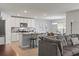 Open-concept kitchen with white cabinets, a granite island, and an adjacent dining area at 13765 Whiskey Daisy Dr, Dade City, FL 33525
