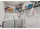 Functional laundry room equipped with a Whirlpool washer and dryer, complemented by wire shelving at 13765 Whiskey Daisy Dr, Dade City, FL 33525