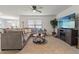 Cozy living room featuring a comfortable sofa, entertainment center, and a bright window at 13765 Whiskey Daisy Dr, Dade City, FL 33525