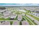 A picturesque aerial view of a neighborhood with houses, pond, and lush greenery at 1398 Crescent Hoop Way, Wesley Chapel, FL 33543
