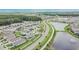 An aerial view of the community with a lake, green spaces, mature trees, and several single-Gathering homes at 1398 Crescent Hoop Way, Wesley Chapel, FL 33543
