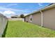 Spacious backyard featuring lush green grass and a partial view of the home's exterior at 1398 Crescent Hoop Way, Wesley Chapel, FL 33543