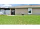 View of the grassy backyard and the covered screened-in patio area of the home at 1398 Crescent Hoop Way, Wesley Chapel, FL 33543