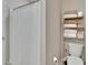 Well-lit bathroom with a clean shower curtain and convenient towel storage shelf at 1398 Crescent Hoop Way, Wesley Chapel, FL 33543