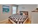Comfortable bedroom with a stylish quilt, nautical wall art, and natural light streaming through the window at 1398 Crescent Hoop Way, Wesley Chapel, FL 33543